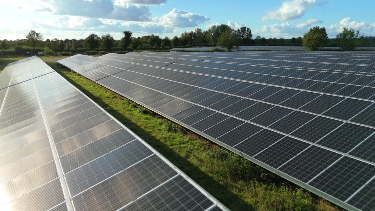 Primo piano con drone al tramonto di pannelli fotovoltaici con riflessi scintillanti e orizzonte paesaggistico in Inghilterra
