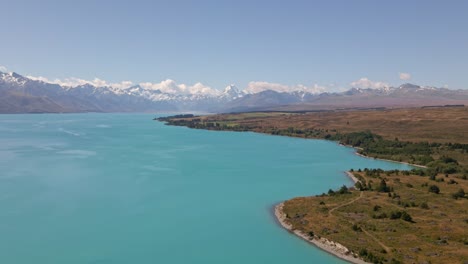 Luftaufnahme---Wunderschöne-Uferlinie-Des-Lake-Pukaki,-Neuseeland-Mit-Mount-Cook-Im-Hintergrund