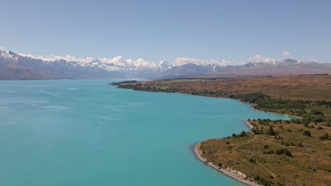 aerial - beautiful shore line of lake pukaki, new zealand with mount cook in background