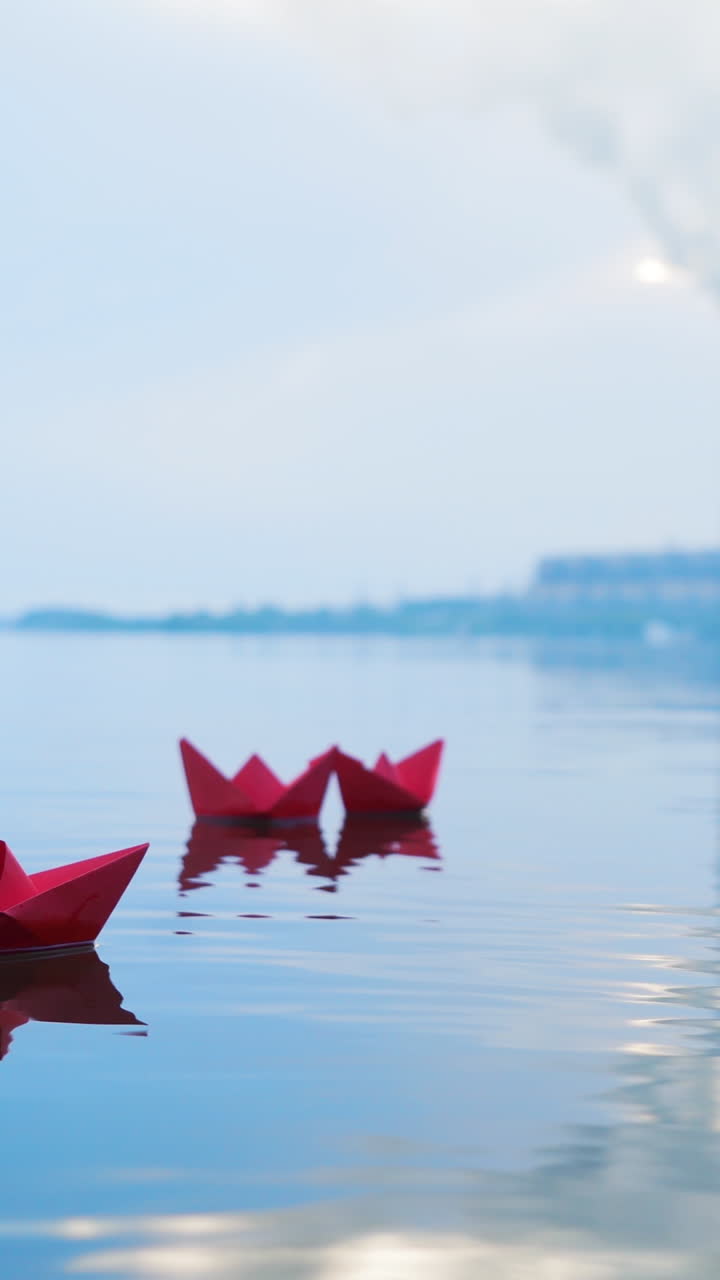 Paper boats floating on a river. Origami. Vertical video