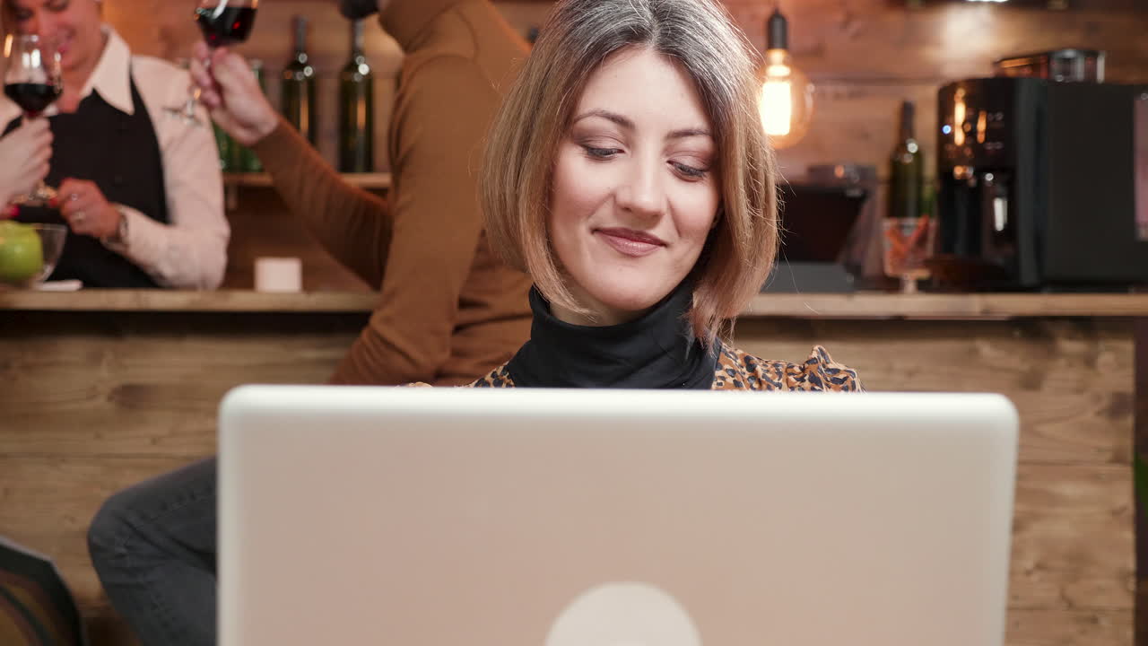 mujer trabajando en una computadora portátil en un café