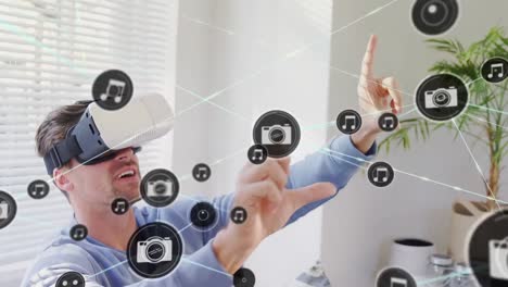 Animation-of-network-of-connections-with-icons-over-man-wearing-vr-headset