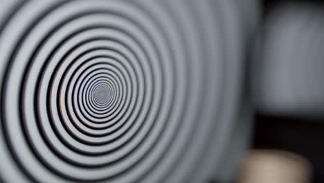 a computer screen in foreground focus with a latop and a mobile phone out of focus, all displaying a hypnotic spiral pattern