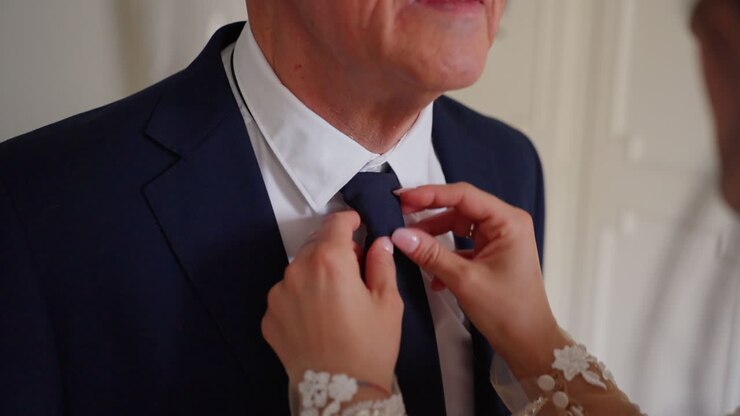 Bride adjusts father's tie, a heartfelt wedding preparation moment