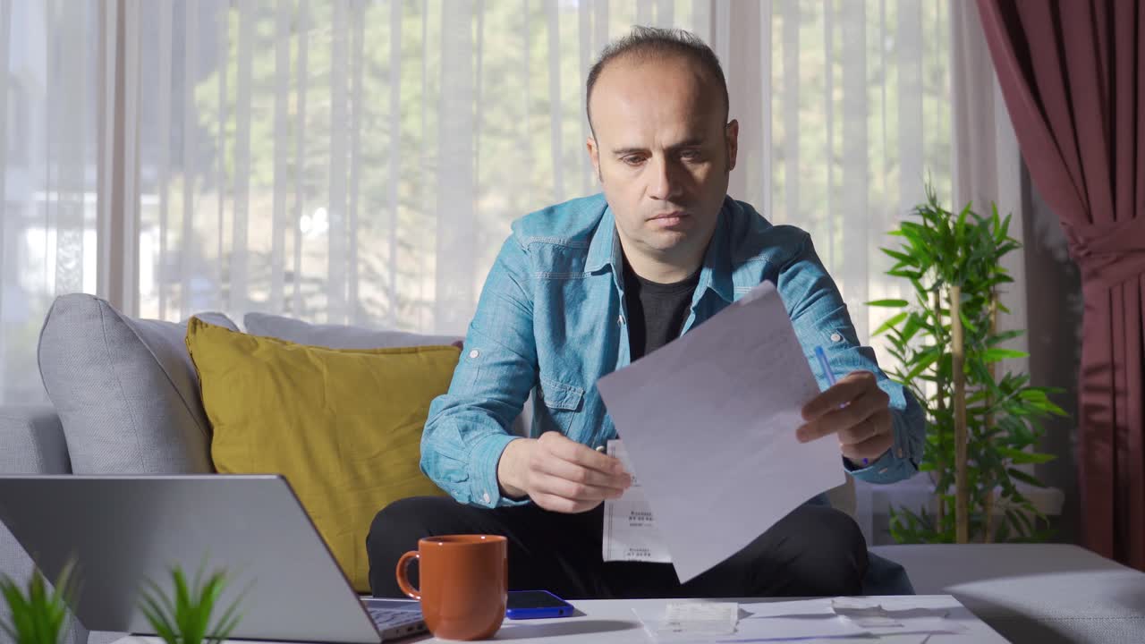 el hombre que calcula el presupuesto del hogar mira las facturas y el correo electrónico.