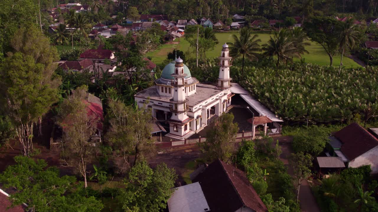 La moschea di Malang con palme lussureggianti e il vulcano Semeru