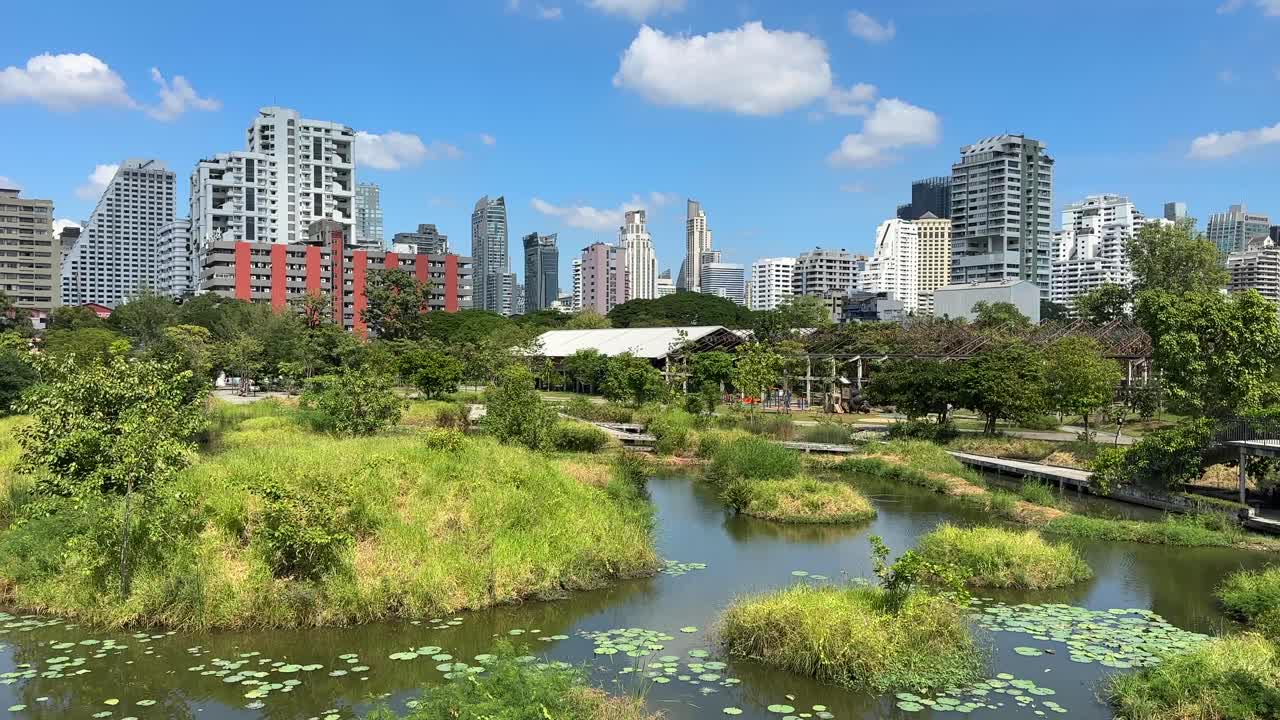 Bangkok Skyscrapers Skyline View from Benchakitti Park – City Buildings Behind Lake and Green Nature, Central Bangkok Thailand, Southeast Asia Urban Landscape Video
