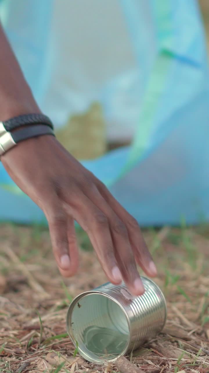 Person Disposing of Trash into a Blue Bag
