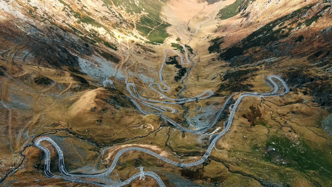 Aerial drone view of nature in Romania. Transfagarasan route in Carpathian mountains, Balea Lake resort and rocky slopes, valley, clouds