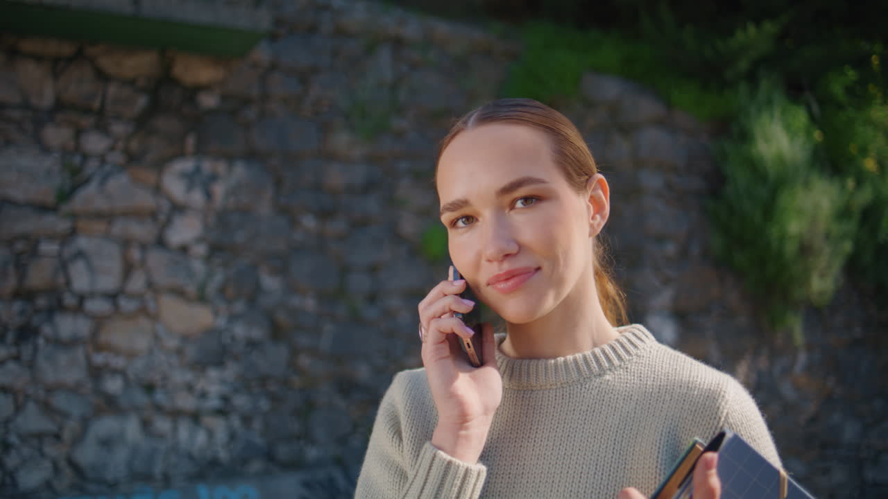 Cute student talking smartphone posing at city portrait. Happy lady calling