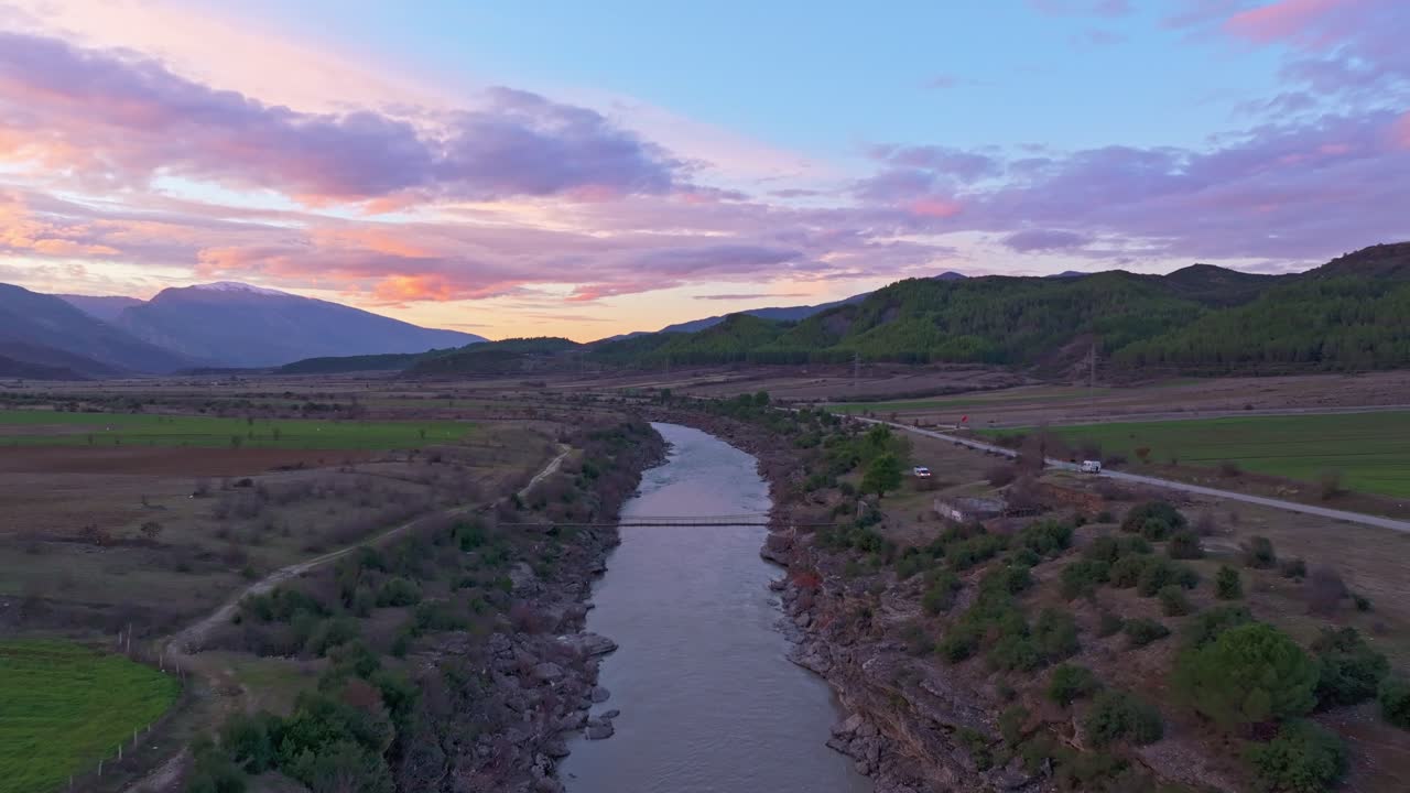 Ripresa aerea del Ponte di Ile che risplende di luce dorata sul fiume, Albania