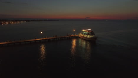 Aerial-view-of-pontoon-on-the-sea-and-people-walking-on-it-from-cruise-boat-at-the-evening-Greece