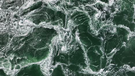 churning, swirling white water below a surge barrier as seen from above