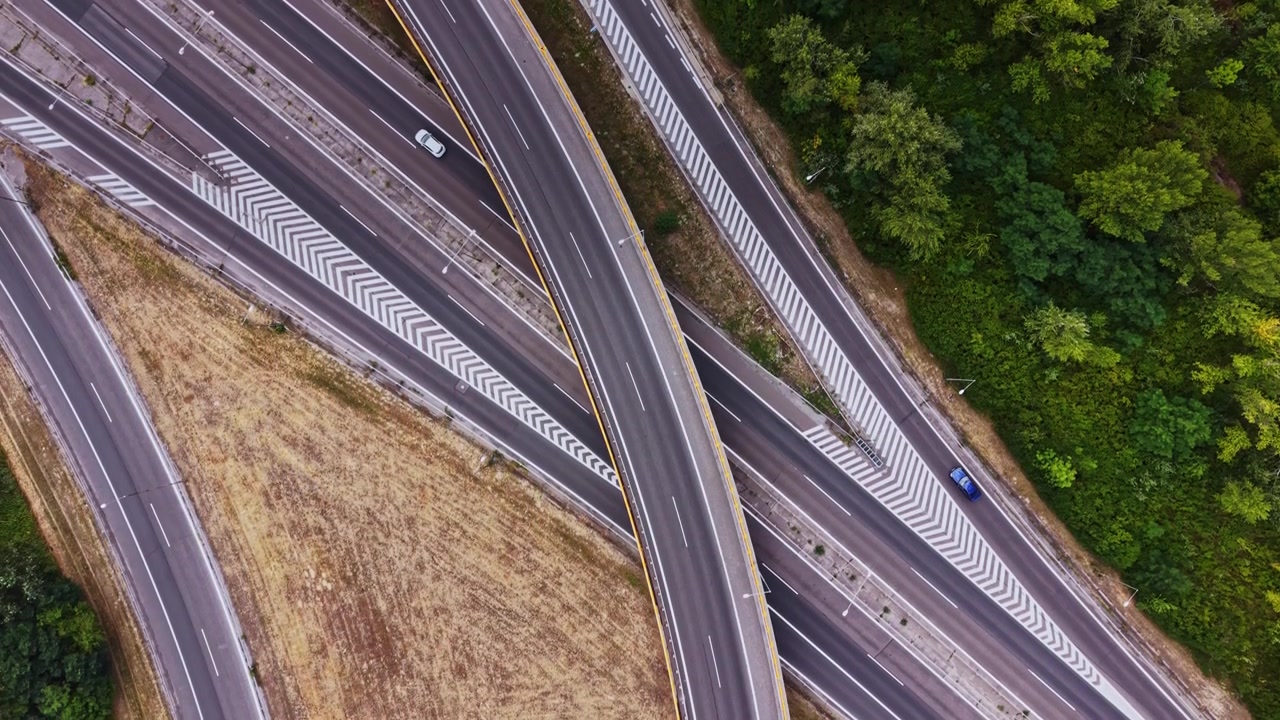 Curve autostradali sopra un campo arido con veicoli che viaggiano sotto