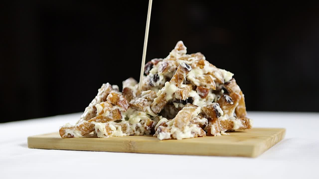 치즈와 함께 전통적인 마늘  한 조각을 러 나무 접시에서 뽑는 사람의 느린 동작 클립