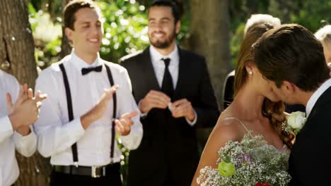 Novia-Y-Novio-Besándose-E-Invitados-Aplaudiendo-En-El-Fondo-4k-4k