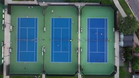 people playing tennis on luxurious recreational courts in a city park