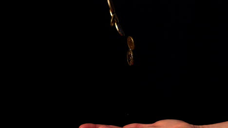 hand throwing euro coins on black background