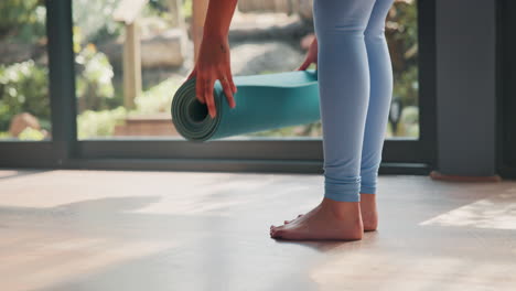 mujer enrollando una alfombra de yoga