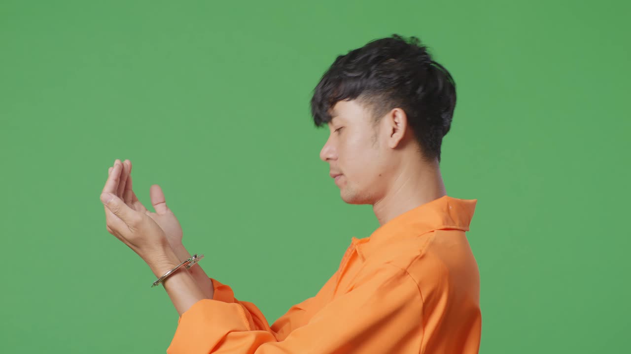 오렌지색 스웨터와 수갑을 입은 남자