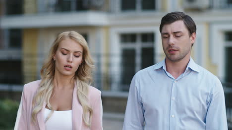 Closeup-colleagues-talking-at-street.-Business-couple-walking-together-outdoor