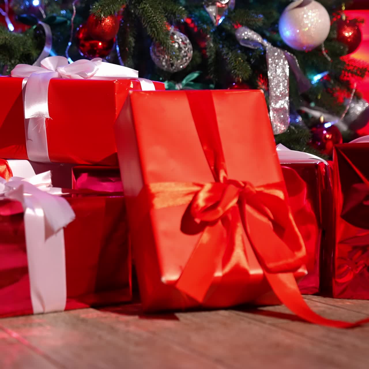 Presents for children at Christmas night. Bright boxes tied with ribbons under the Christmas tree. Many gifts in the room from Santa Claus. New Year eve