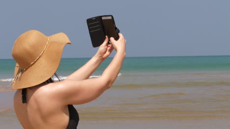hermosa mujer caucásica se está tomando selfie en la playa tropical
