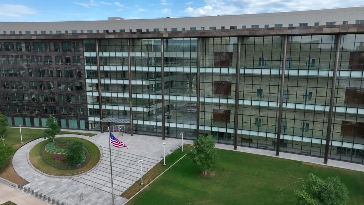 Modern building with glass fa&ccedil;ade and American flag in front