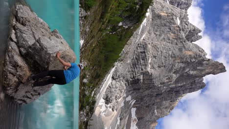 vertical video of caucasian man climbing rock in lago di sorapiss, dolomites