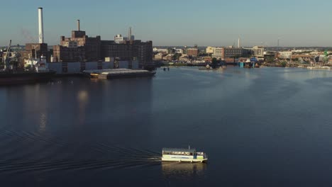 settling aerial shot showing water taxi heading to fells point on patapsco river in baltimore maryland in the morning