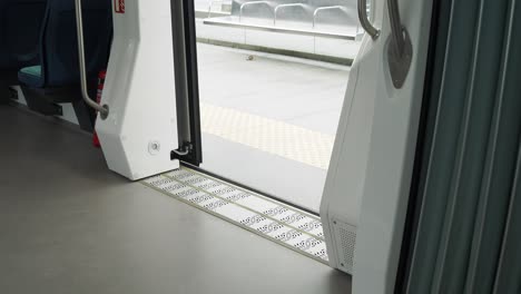 open doors of a modern light rail car at a station