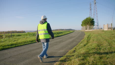 subestación de energía rural, trabajador dirigiéndose a la zona segura cerrada