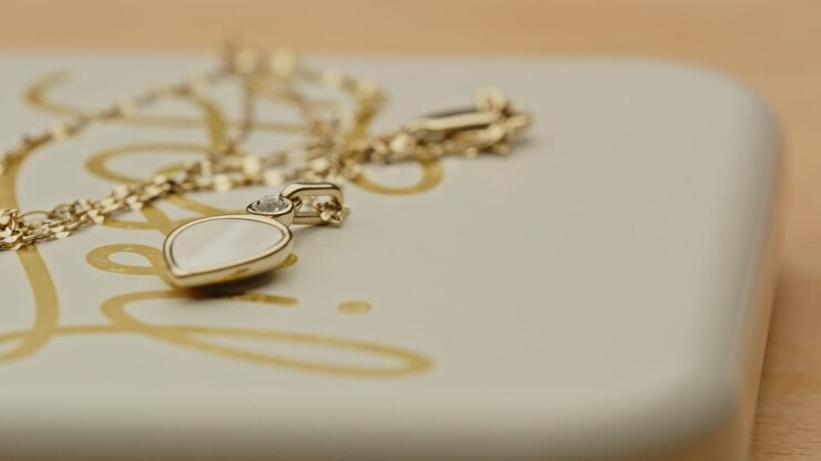 Ripresa panoramica di una bellissima collana d'oro con uno splendido medaglione sul coperchio di un portagioie