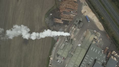 Vista-Superior-De-La-Planta-De-Carpintería-Con-Humo-De-Chimenea-Y-Pila-De-Maderas-En-Portlaoise,-Condado-De-Laois,-Irlanda