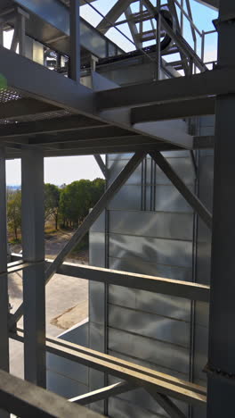facility frame construction. industrial plant at sunlight. steel equipment of agricultural granary. exterior of a factory. close-up. vertical video