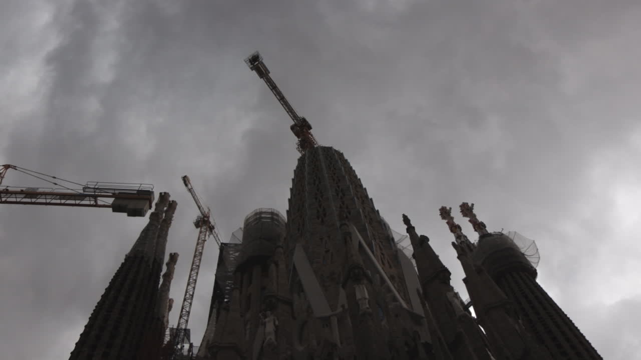Crane working on La Sagrada Familia Pillar under construction. Dark cloudy day time.