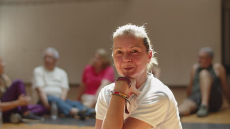 Slow-motion-of-happy-woman-sitting-in-dance-studio-after-workout