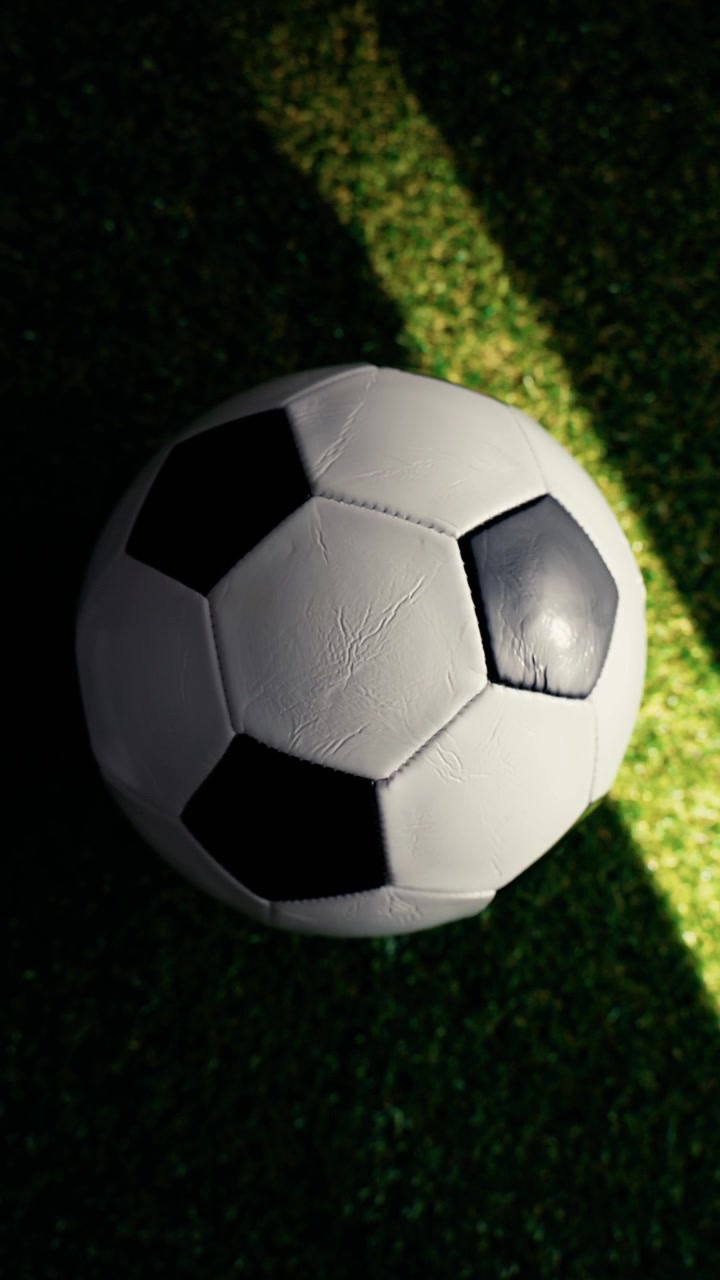 Balón de fútbol reposando sobre un campo de césped artificial