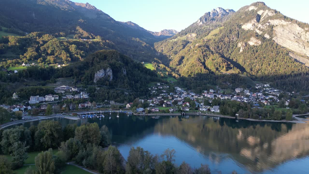 un pueblo alpino junto a las montañas y el lago walensee en vista panorámica aérea