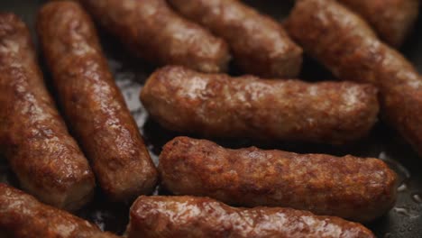 crop person turning homemade sausages frying in pan