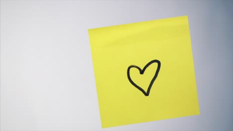 nota adhesiva amarilla con un corazón