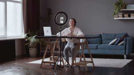 wide shot of a vlogger woman answering questions to her followers about make up and cosmetic products