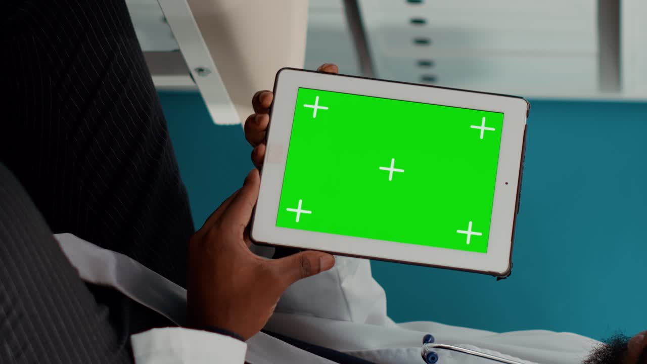Male medic working with greenscreen on tablet at examination