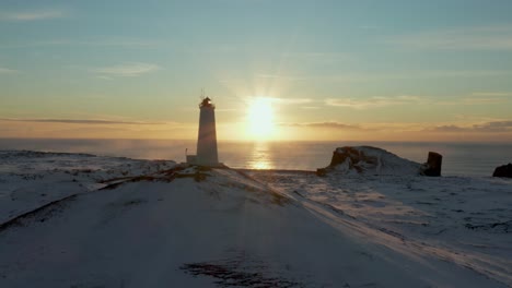 scenic view of reykjanesviti lighthouse on hill top at snow covered coastline