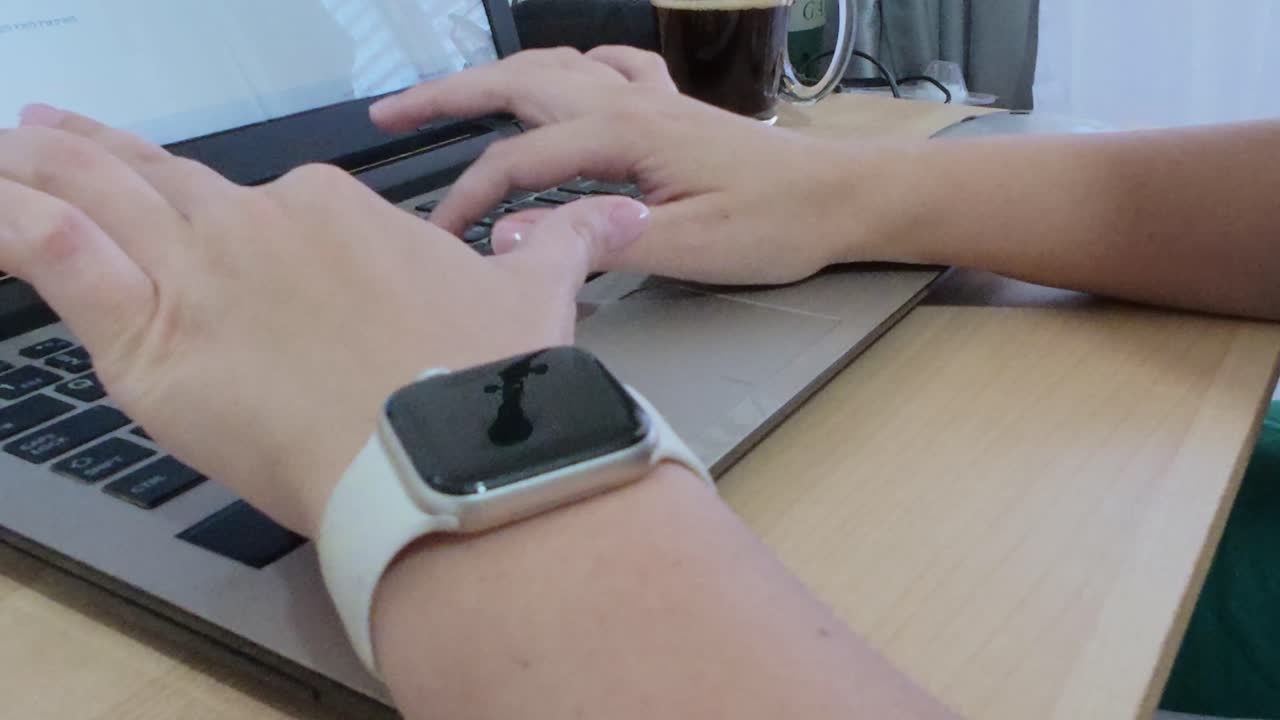 Student's hands typing on a laptop during an online class or study session.