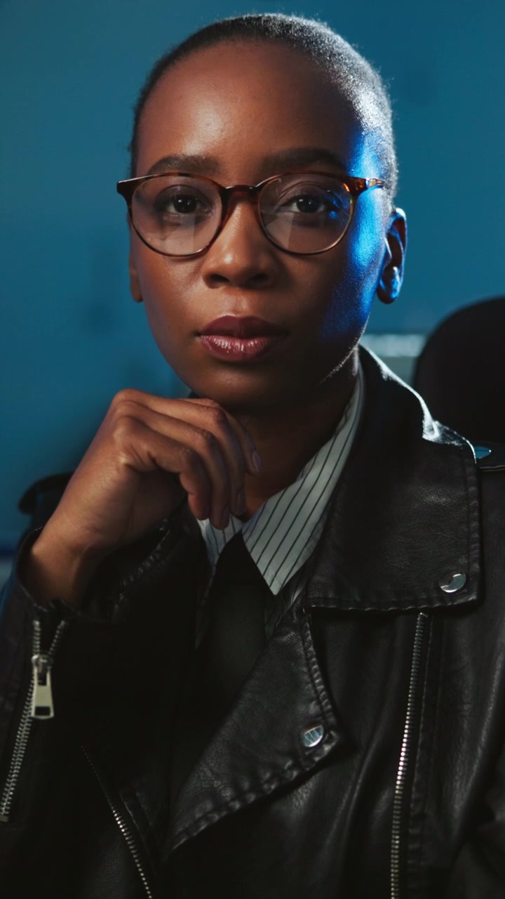 Confident Young Woman Working in a Dark Tech Office