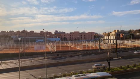 Von-Oben-Nach-Unten-Luftaufnahme-Der-Skyline-Der-Stadt-Madrid-Am-Frühen-Morgen-Mit-Blauem-Himmel-Und-Tennisplatz-Im-Vordergrund