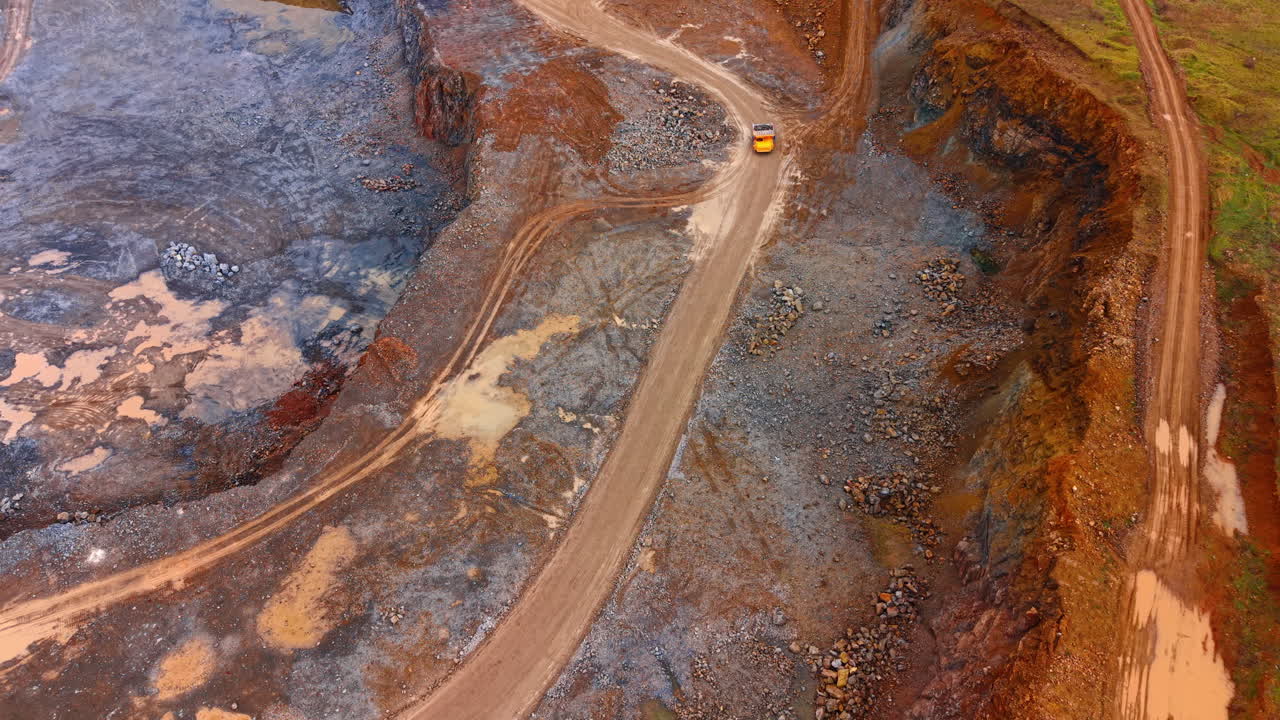 Mining site construction near mountain. Heavy machinery moves over a rocky surface at a mining site during daytime. Workers manage the extraction process