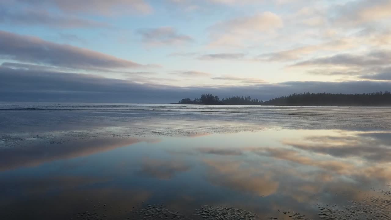 Panning shot of beautiful reflecting waters during sunset at Long Beach on Vancouver Island