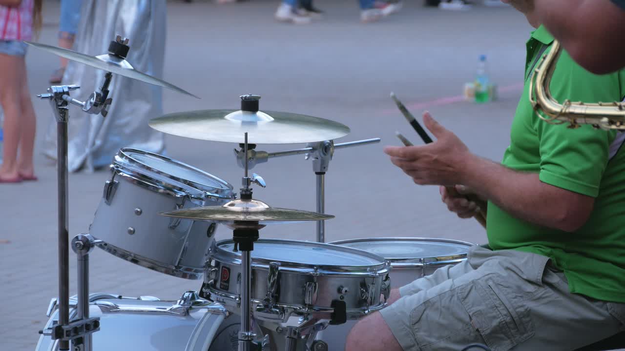 baterista calentándose con palos de batería en el fondo de la calle de la ciudad por la noche. hombre tocando jazz, rock y música metal en la batería. ensayo de la banda de música jamming 4k imágenes.